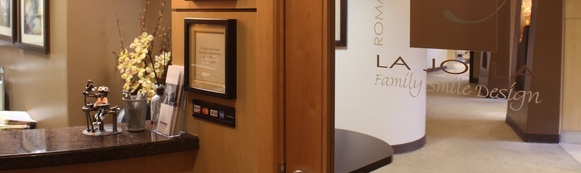 Modern dental office interior with warm wood tones, reception desk, and professional waiting area.
