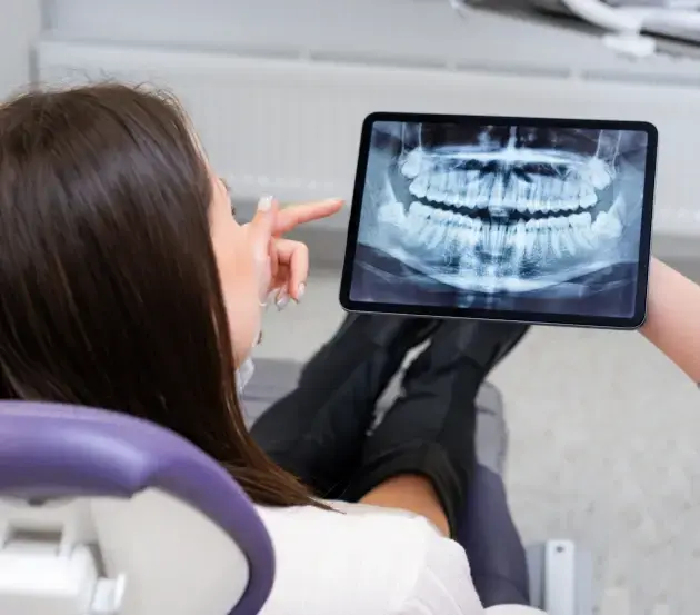 Patient reviewing digital panoramic x-ray of teeth with dentist in Colorado Springs office.